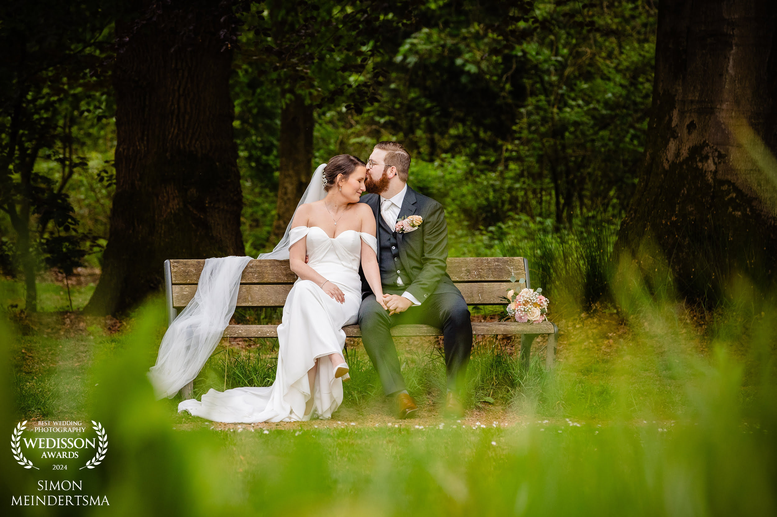 Bruidspaar op bankje tijdens fotoshoot met trouwfotograaf op landgoed rhederoord